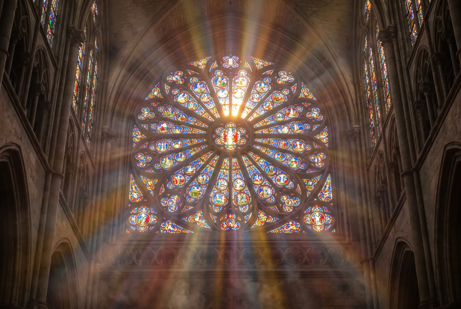Sunlight streaming through a stained-glass rose window